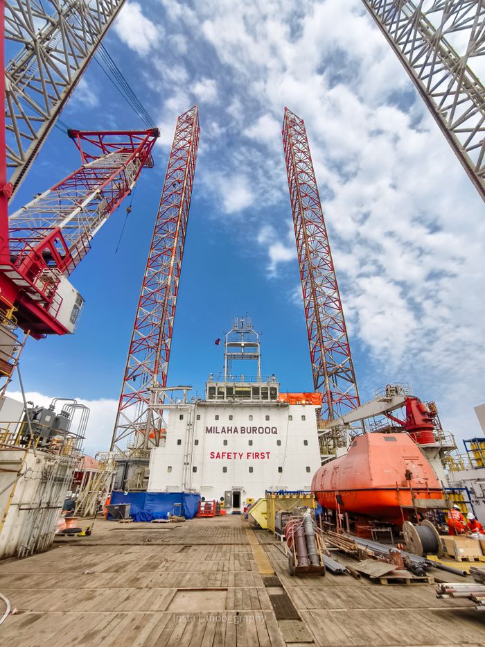 Mastering the First Impression: Your intriguing post title goes here Oil rig platform with cranes and safety message under clear blue sky.